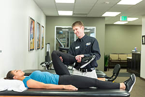 Physical therapist working on leg stretches with patient.