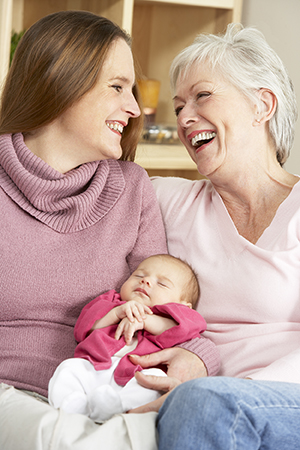 New mother and grandmother holding newborn baby girl..