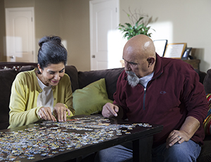 Man and woman doing jigsaw puzzle.