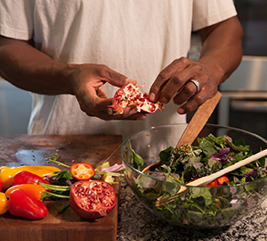 Man making salad in kitchen.