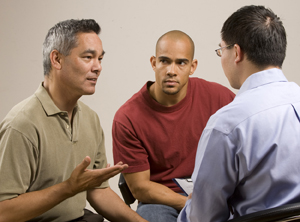 Two men in group discussion with healthcare provider.