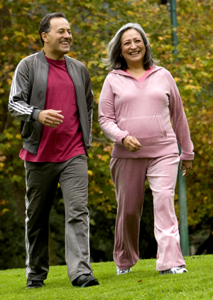 Man and woman outdoors walking in comfortable clothes.