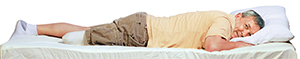 Man with amputated leg lying face down on stomach, head supported by pillow.
