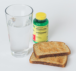 Toast, glass of water, and two pills.