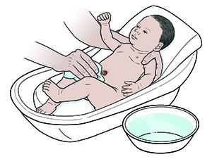 Newborn baby being bathed.