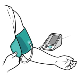 El brazo de una persona descansa sobre una superficie plana con la palma de la mano hacia arriba, la manga de la camisa enrollada y el manguito para la presión arterial colocado alrededor de la parte superior del brazo, por encima del codo.