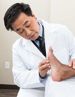 Health care provider examining a person's foot.