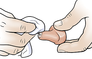 Hand swith cloth cleaning hearing aid.