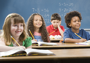 Four children during classroom lesson and one student seems distracted.