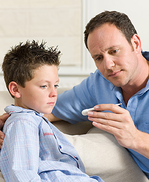 Man taking boy's temperature.