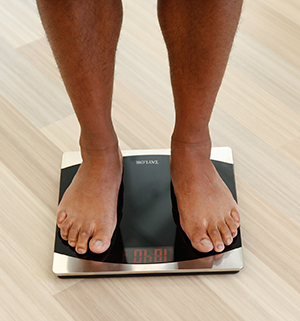 Closeup of person's feet on bathroom scale.