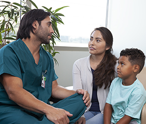 A health care provider talks to a woman and child.