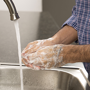 Person washing hands with soap and water.
